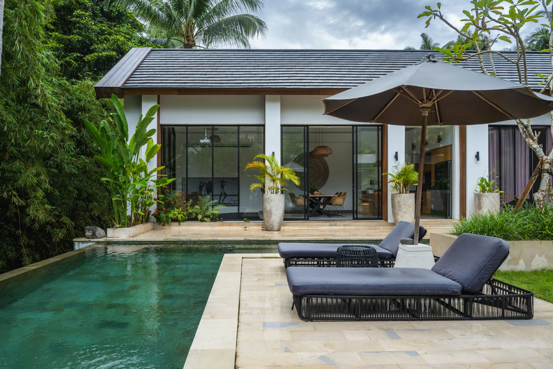 Outdoor loose furniture beside poolside villa with weather-resistant hospitality seating